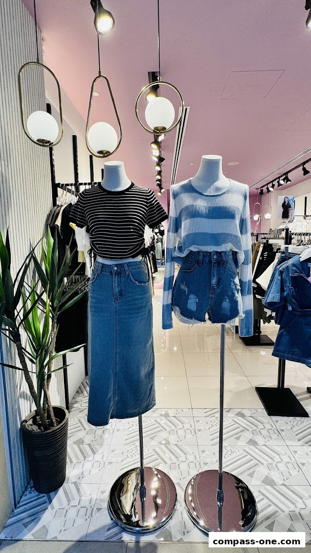 Mannequins display stylish outfits in a brightly lit clothing store.
