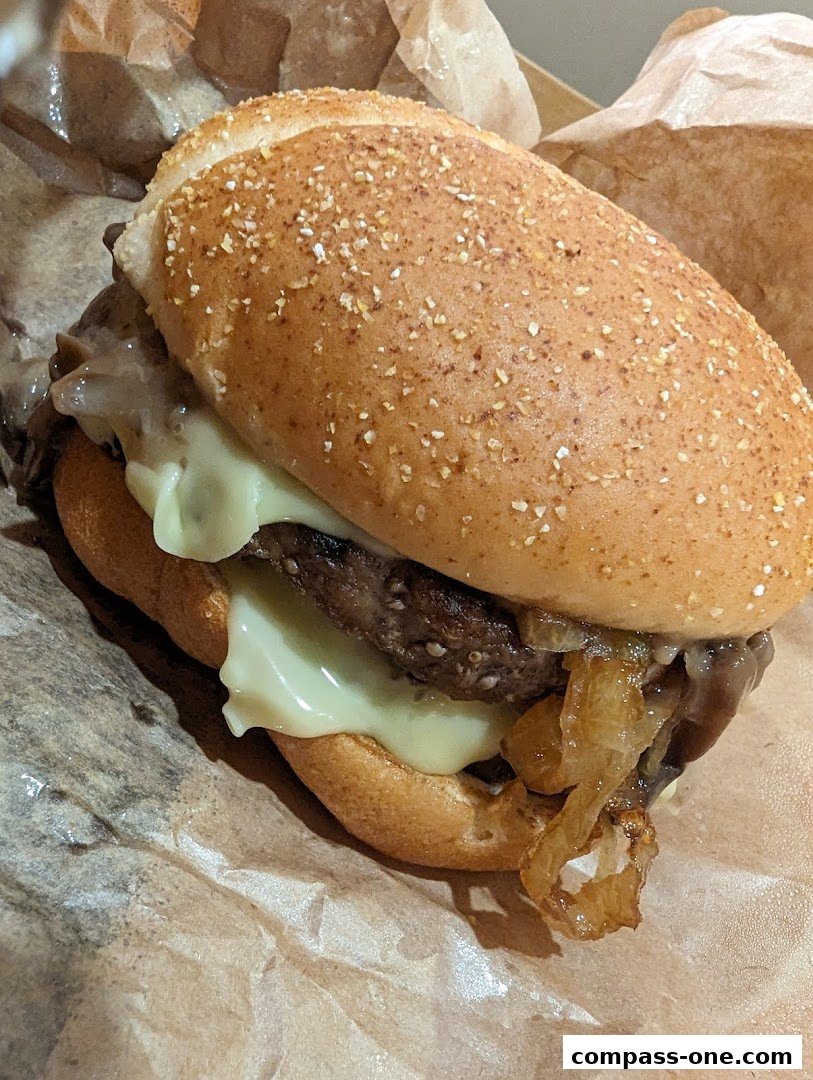 A close-up shot of a juicy burger with melted cheese and caramelized onions.