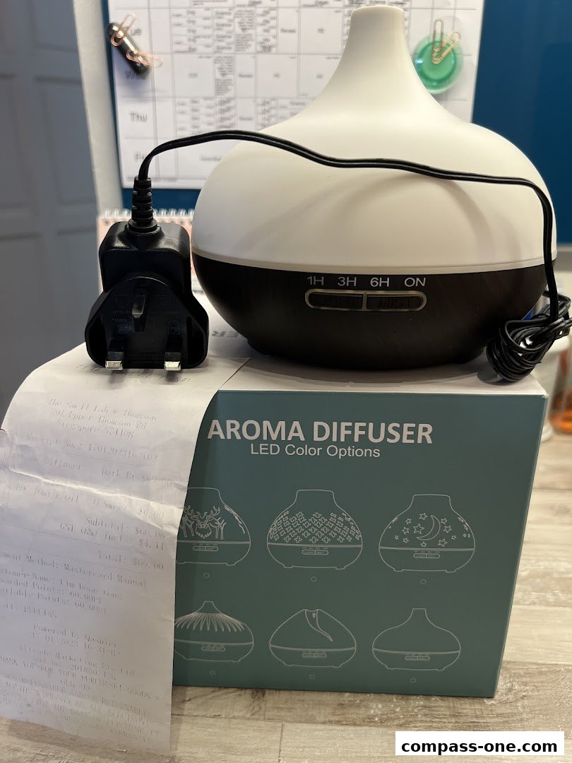 An aroma diffuser with LED color options and its power adapter are displayed with a receipt.
