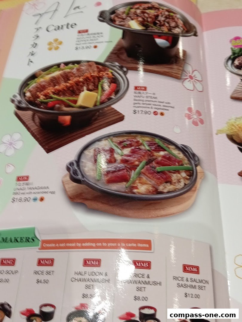 A menu page from Genki Sushi Compass One featuring various Japanese dishes and set meals.