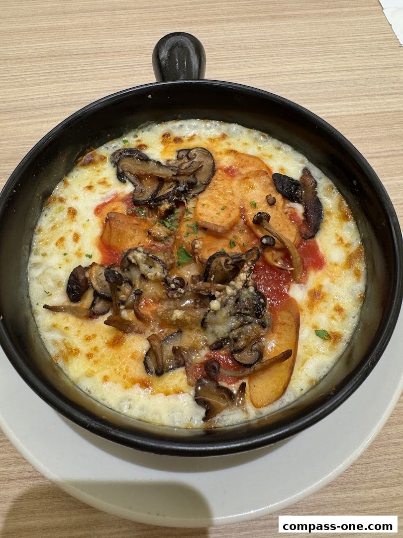 A close-up shot of a delicious baked dish with melted cheese, mushrooms, and sauce.