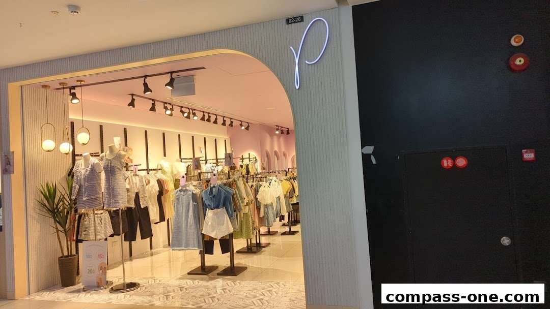 The entrance of a stylish clothing store named Purpur, showcasing fashionable apparel on mannequins and racks.