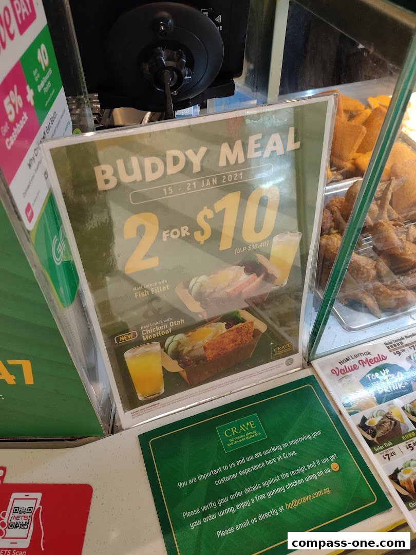 A promotional sign for a 'Buddy Meal' deal at Crave Nasi Lemak, offering two meals for $10.
