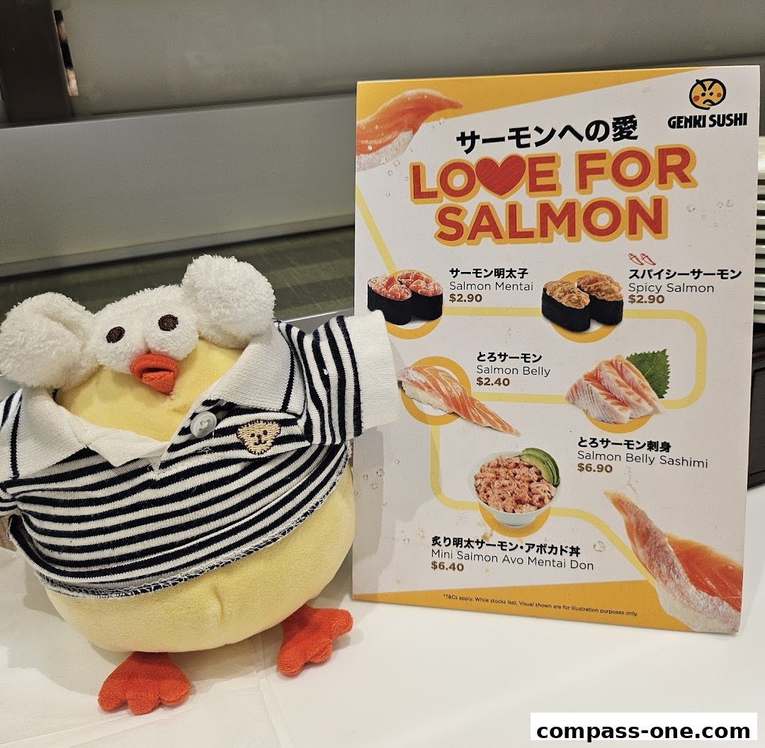 A plush toy sits next to a menu board advertising salmon sushi dishes at Genki Sushi.