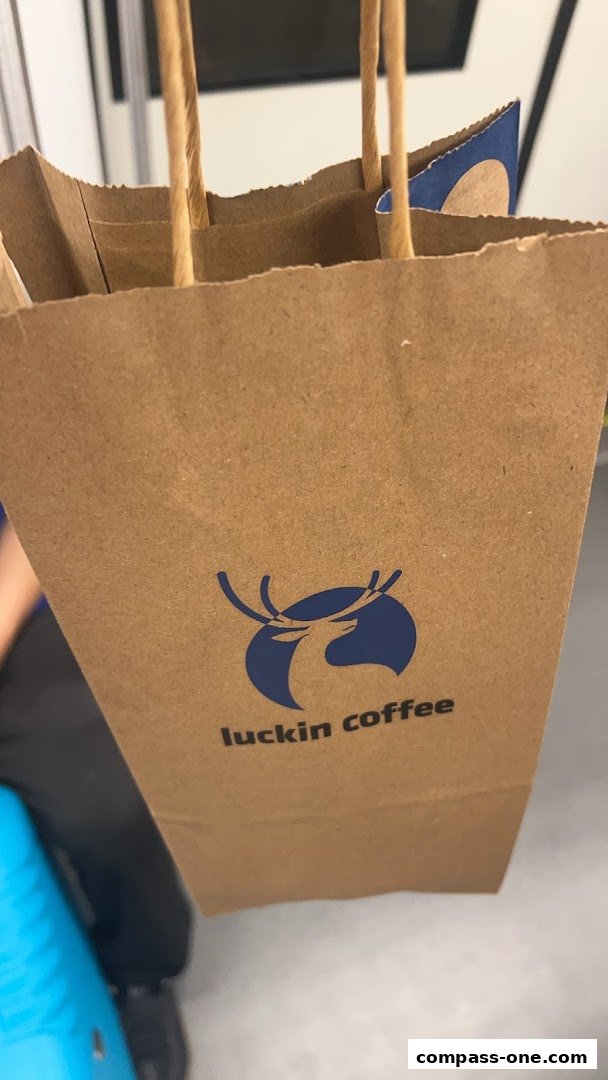 A brown paper bag with the Luckin Coffee logo and handles.