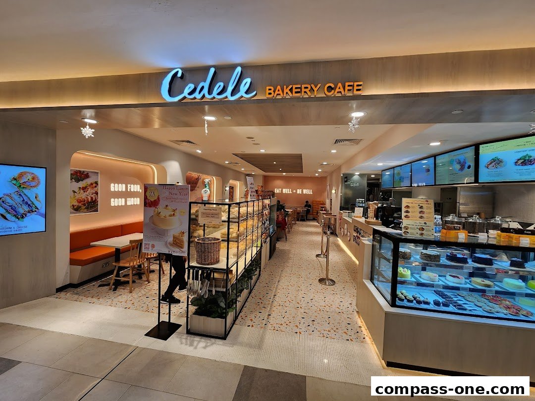The inviting entrance of Cedele Bakery Cafe, showcasing a display of cakes and baked goods.