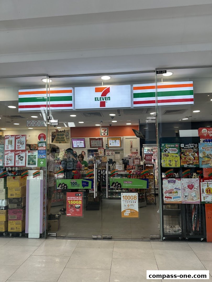 The exterior of a 7-Eleven convenience store with its iconic signage and glass doors.
