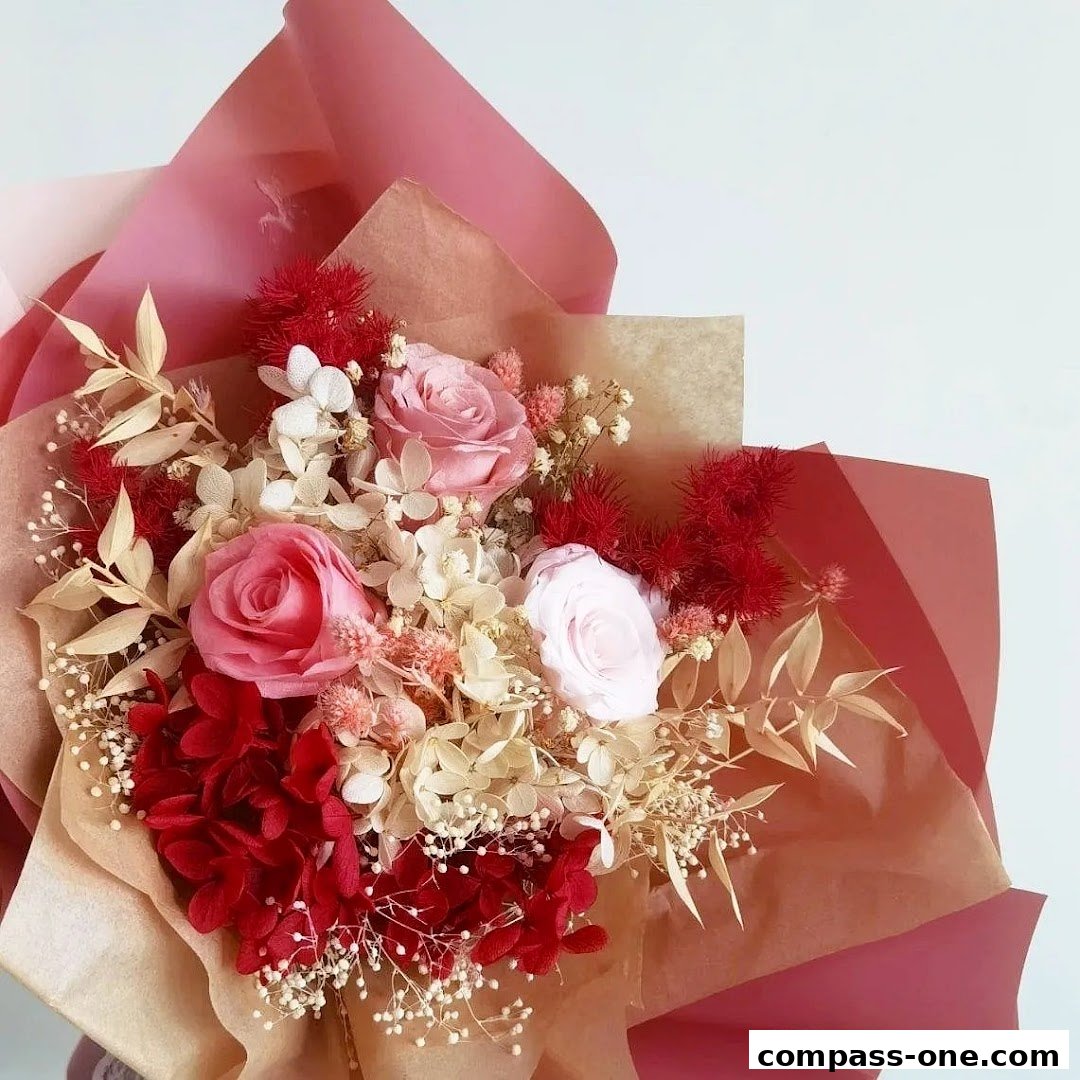 A beautiful bouquet of preserved flowers in shades of pink, red, and cream.