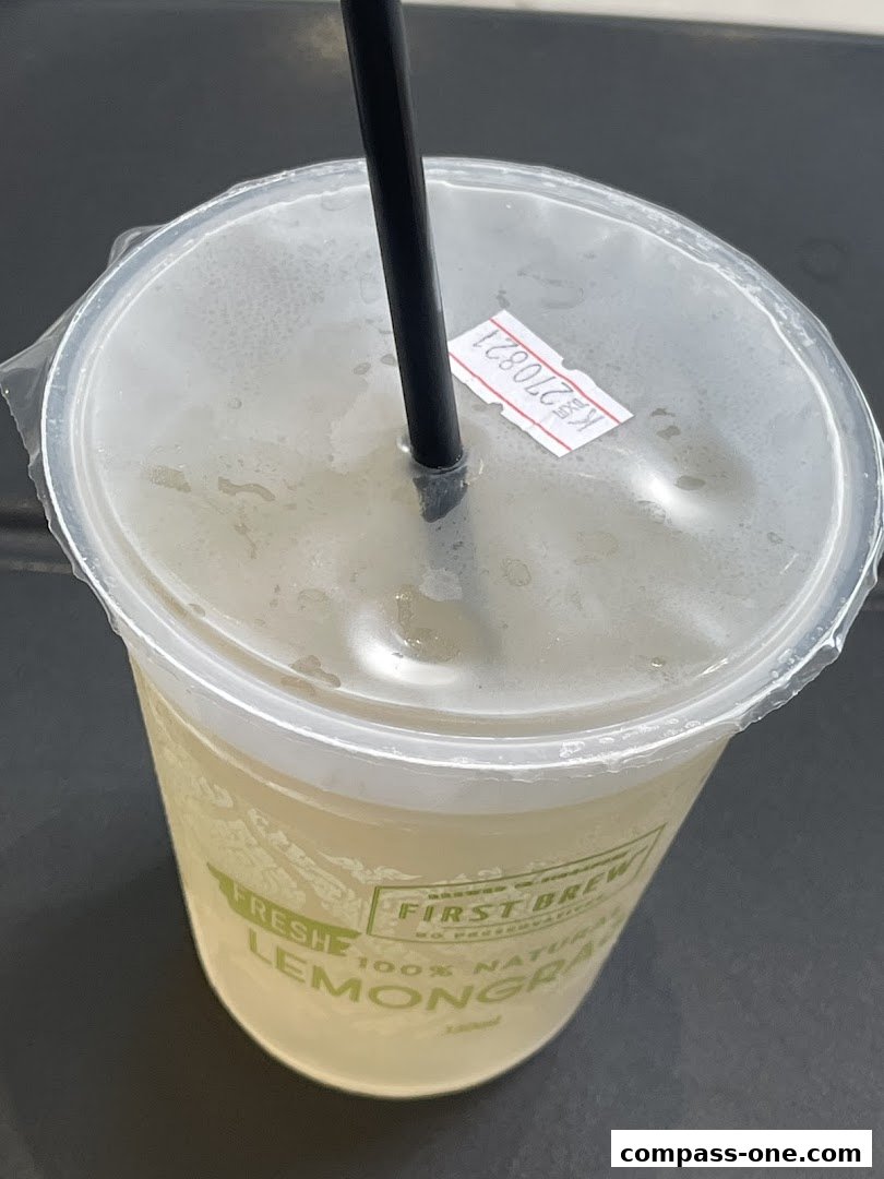 A close-up of a 7-Eleven lemongrass drink with a straw and a price sticker.