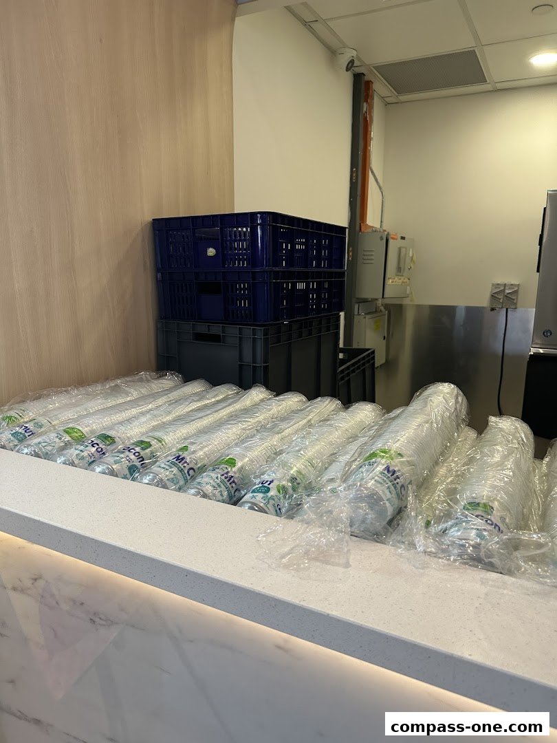 Rows of plastic cups with Mr. Coconut branding are neatly stacked on a counter.