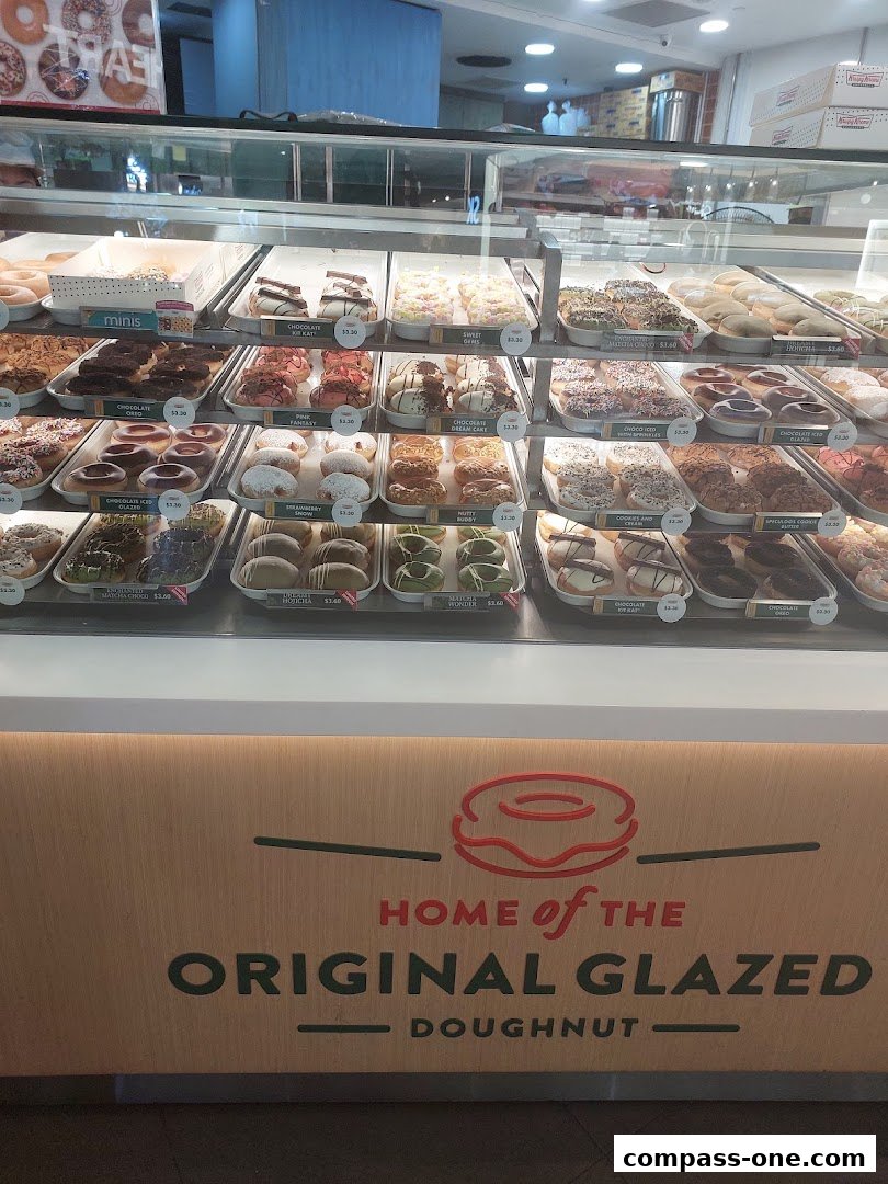A display case filled with a variety of colorful and delicious Krispy Kreme doughnuts.