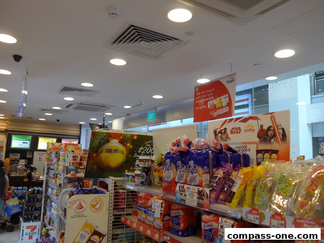 Interior view of a 7-Eleven store with shelves stocked with snacks and promotional displays.