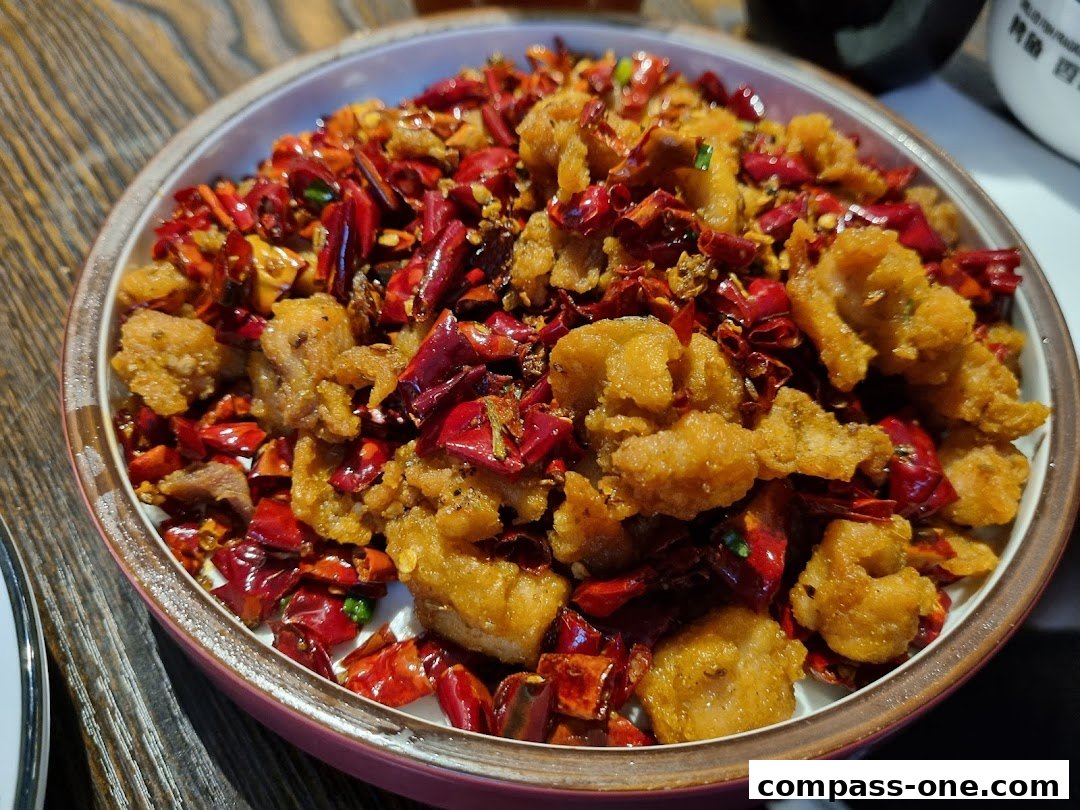A close-up shot of a bowl filled with crispy fried chicken pieces and dried chili peppers.