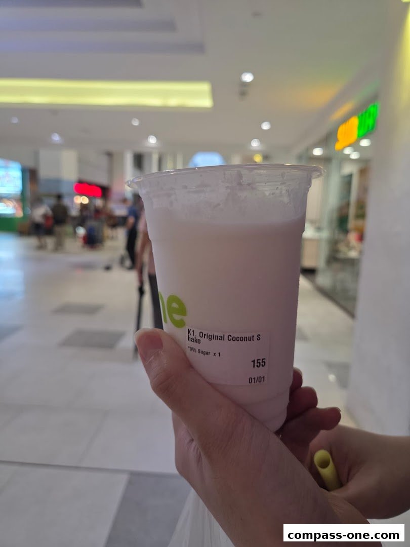 A hand holds a CocoCane Original Coconut Shake with 70% sugar.