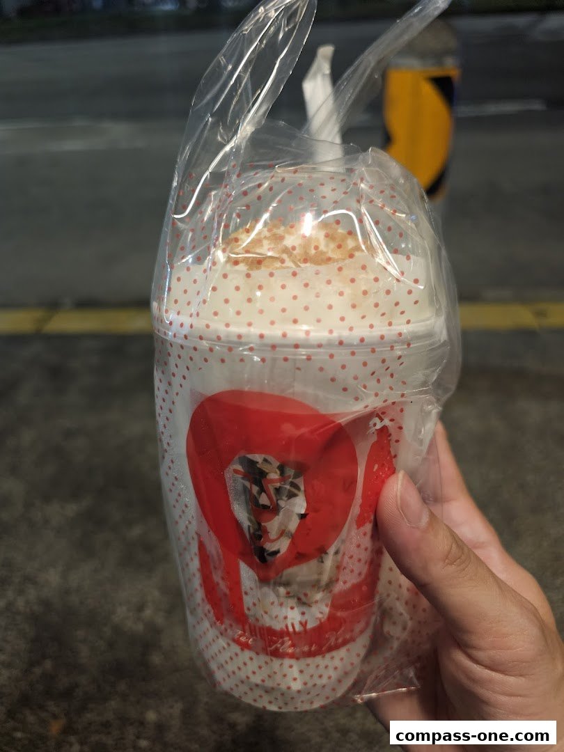 A hand holds a LiHO TEA cup with a red heart logo and polka dots.