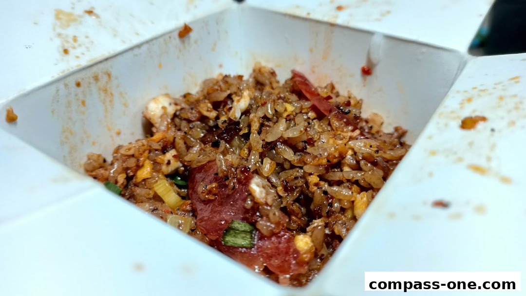 A close-up shot of a takeaway box filled with delicious fried rice and meat.
