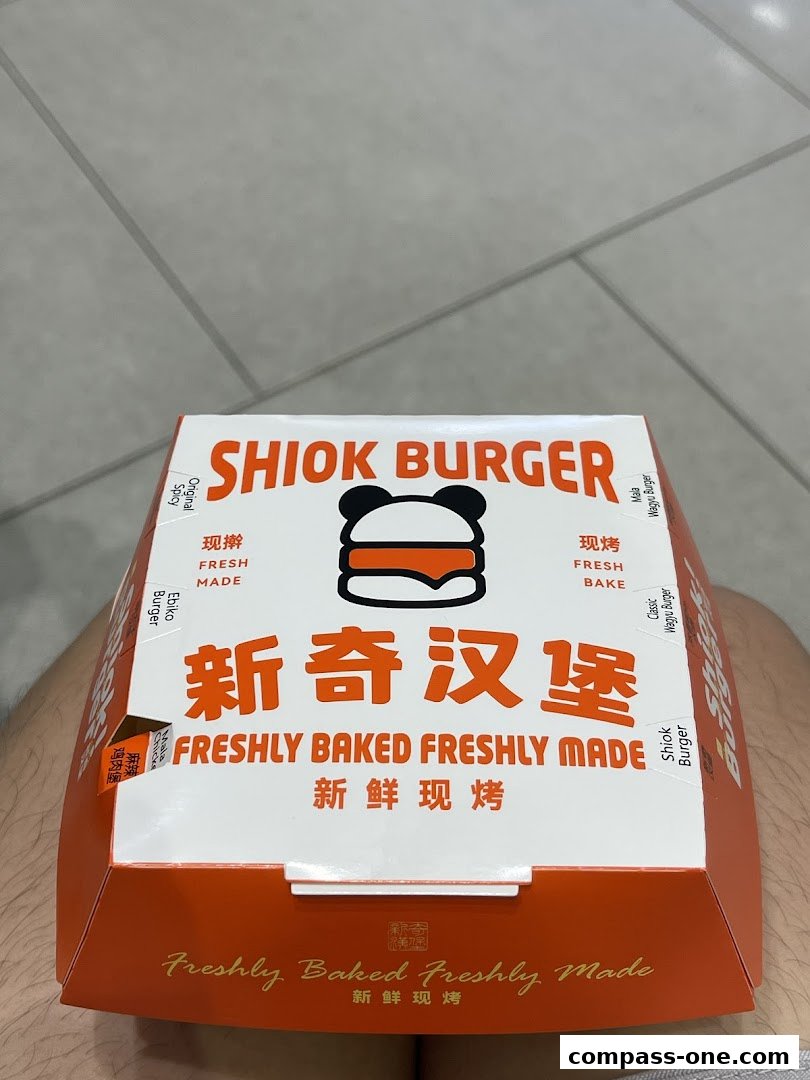 A Shiok Burger takeaway box with the brand name and burger illustration.