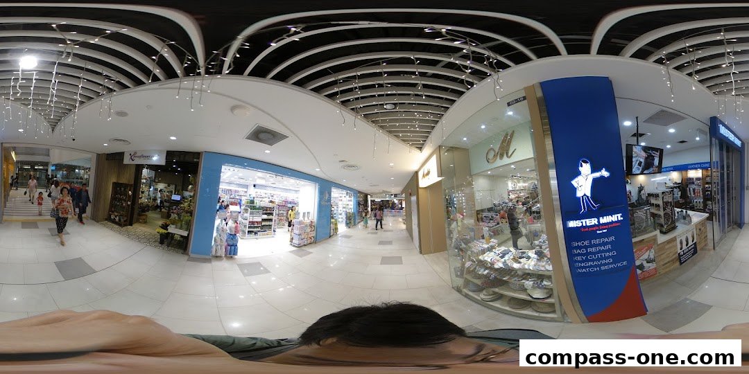 A shopping mall corridor with various shops, including Xpressflower.com and Mister Minit.