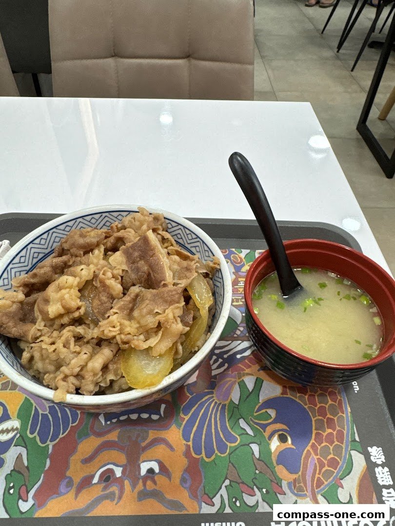 A bowl of Yoshinoya's signature beef bowl with a side of miso soup.