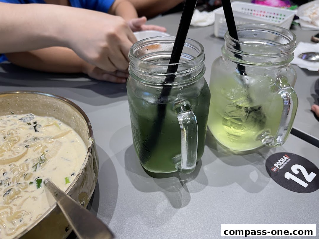 Close-up of Korean street food with two refreshing drinks and a table number.