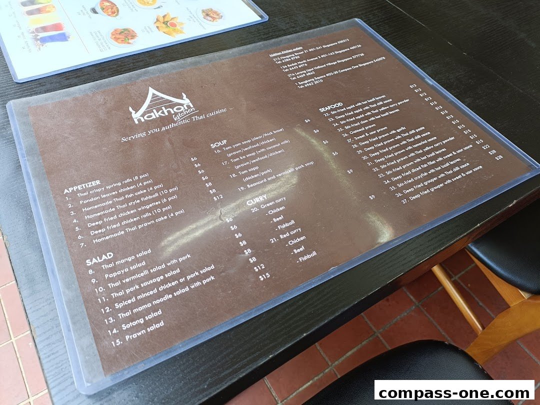 A menu from Nakhon Kitchen, a Thai restaurant, featuring appetizers, salads, soups, seafood, and curries.