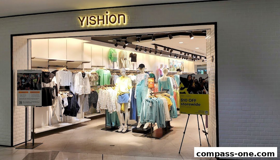 The entrance of a YISHION clothing store showcasing mannequins and apparel on display.