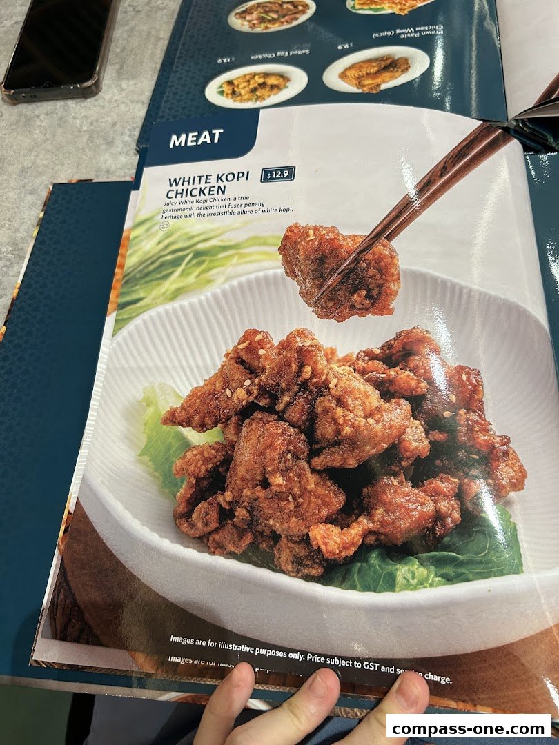 A menu item featuring White Kopi Chicken, presented with chopsticks holding a piece.