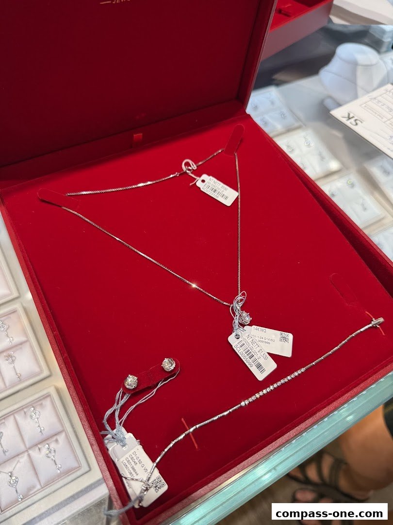 A red jewelry box displaying a diamond necklace, earrings, and bracelet.