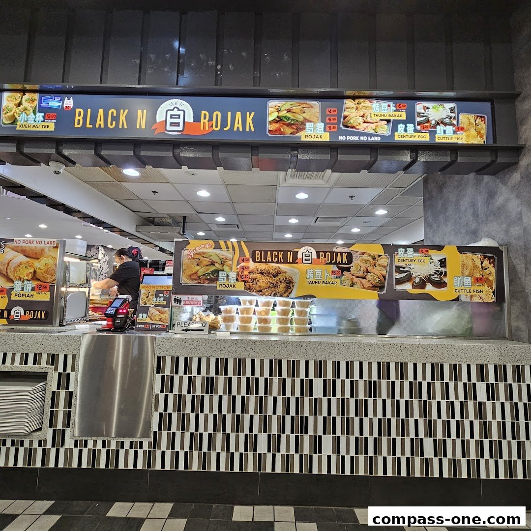 A food stall counter with a menu board displaying various dishes and prices.