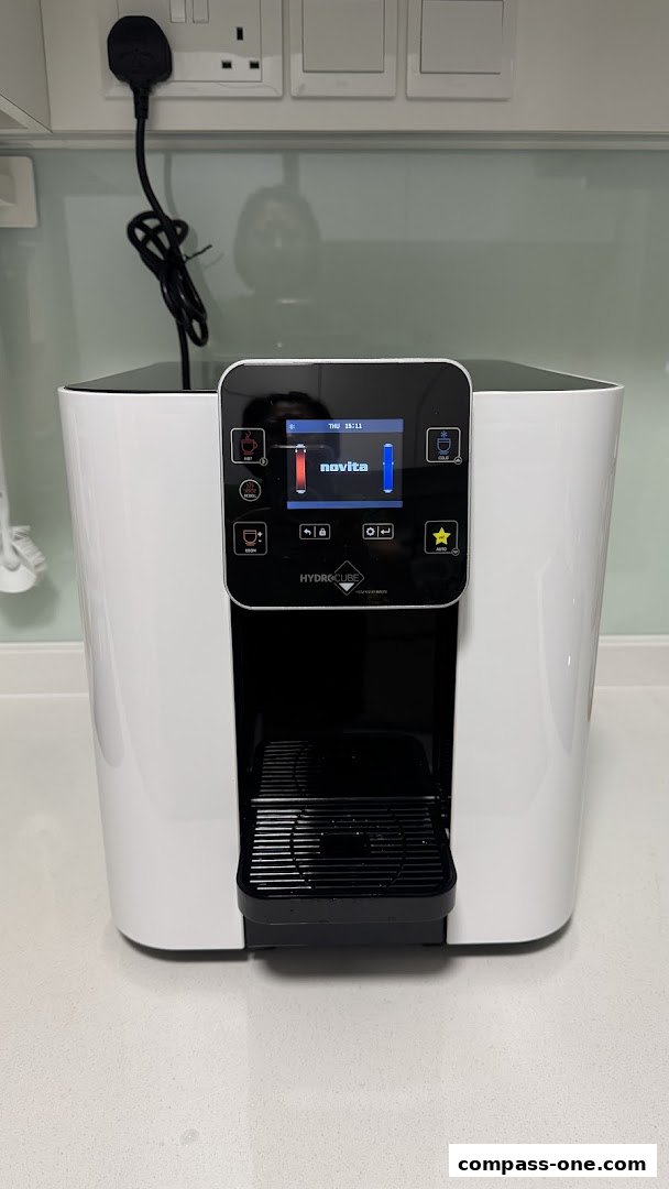 A white HydroCube water dispenser with a digital display showing 'novita'.