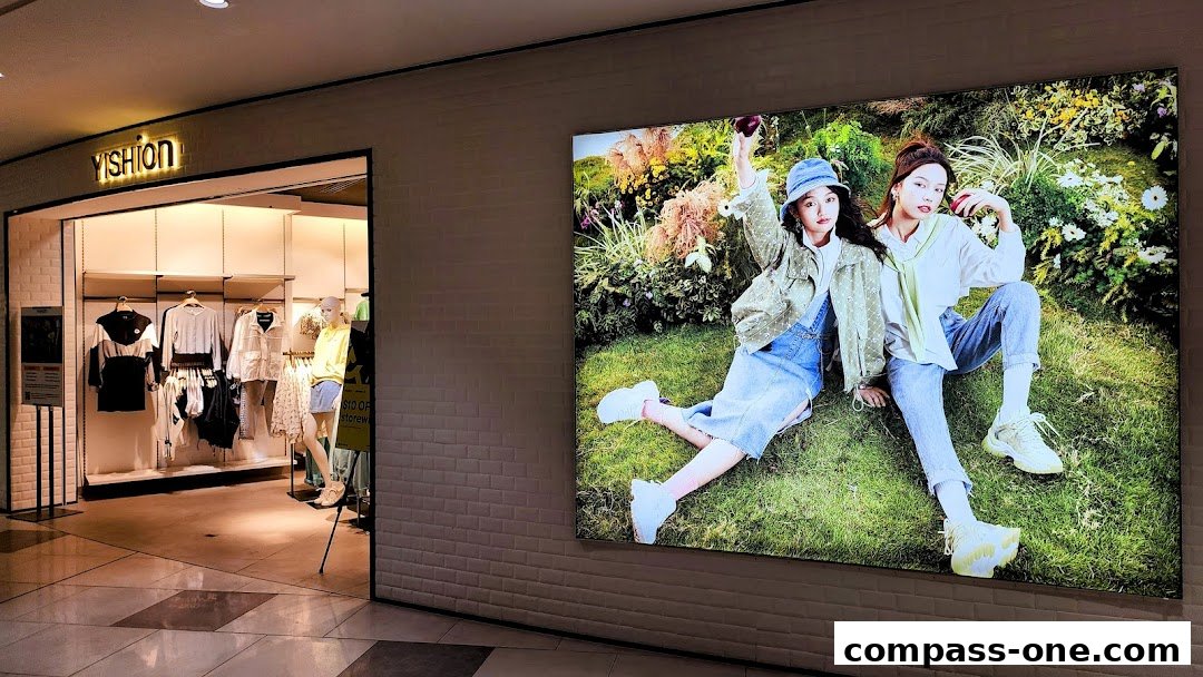 The entrance of a YISHION clothing store with mannequins and clothing displayed inside.