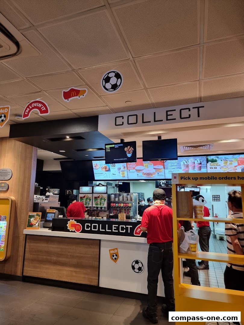 McDonald's counter with staff serving customers and football-themed decorations.