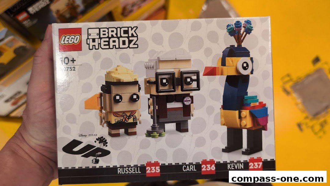 A hand holds a LEGO BrickHeadz box featuring characters from Disney Pixar's Up.