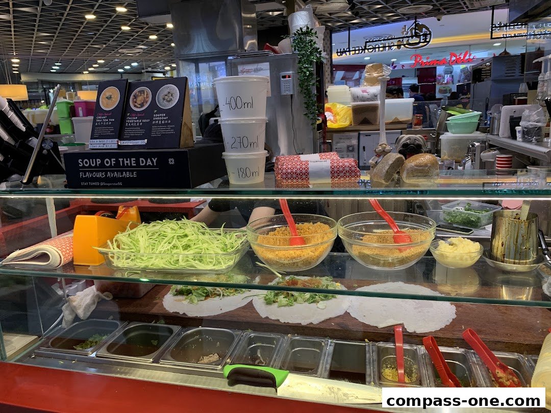 A display of fresh ingredients and soup options at a food stall.