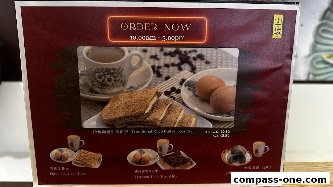 A menu board showcasing traditional Ipoh breakfast items like kaya toast and pork floss toast.