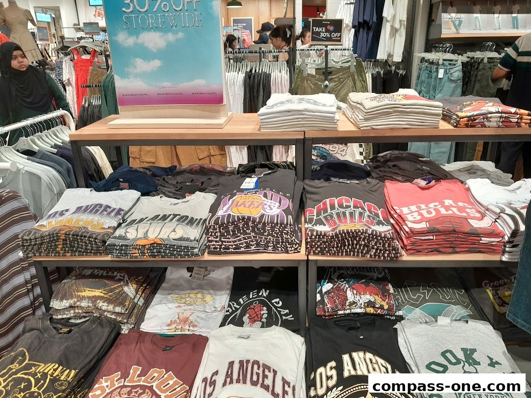 A display of folded graphic t-shirts with various designs and a '30% OFF STOREWIDE' sign.