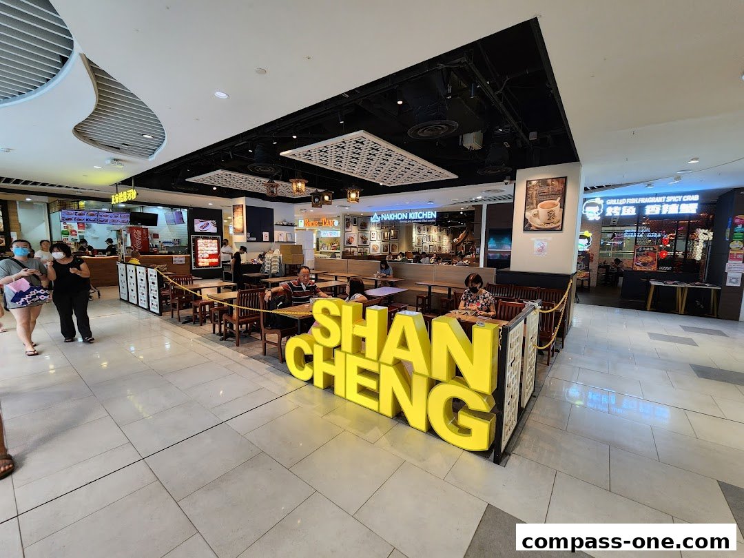 A brightly lit food court area with a prominent 'Shan Cheng' sign and various food stalls.