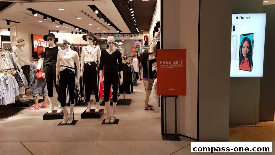 Mannequins display trendy outfits inside a Yishion store, with a promotional sign and iPhone X advertisement visible.