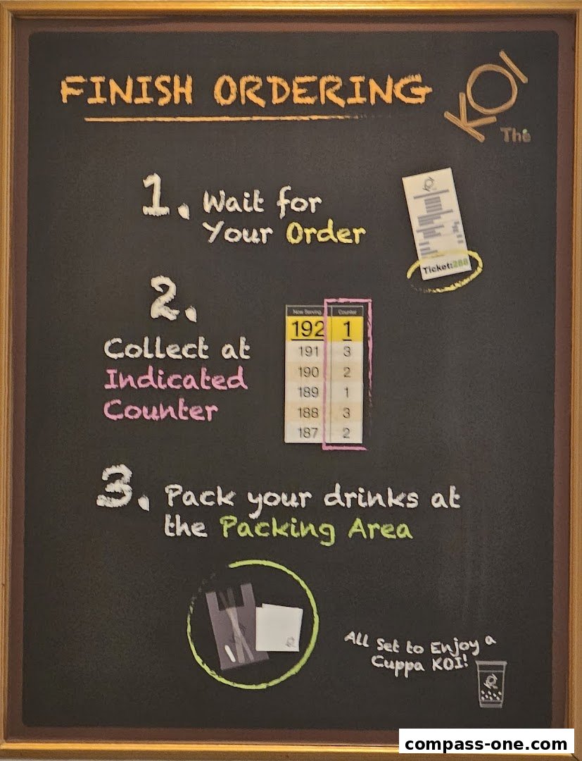 A chalkboard sign at KOI Thé detailing the steps to finish ordering and collect drinks.