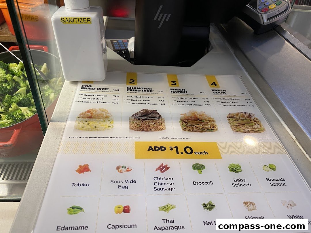 A close-up view of a Wok Hey menu displaying various rice, ramen, and udon dishes with prices.