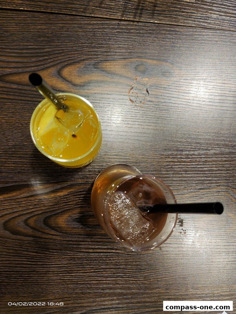 Two refreshing drinks with straws on a wooden table.