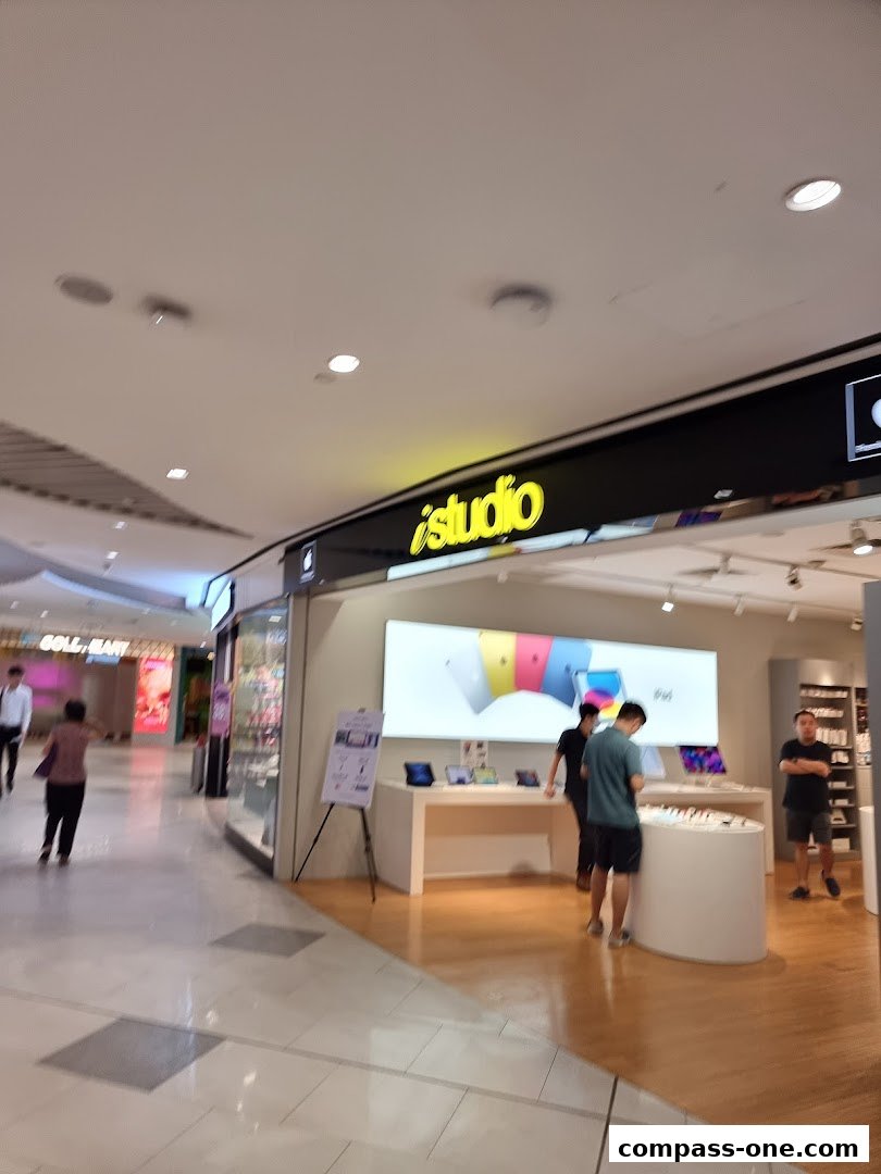 The iStudio store front displays Apple products and has customers browsing inside.