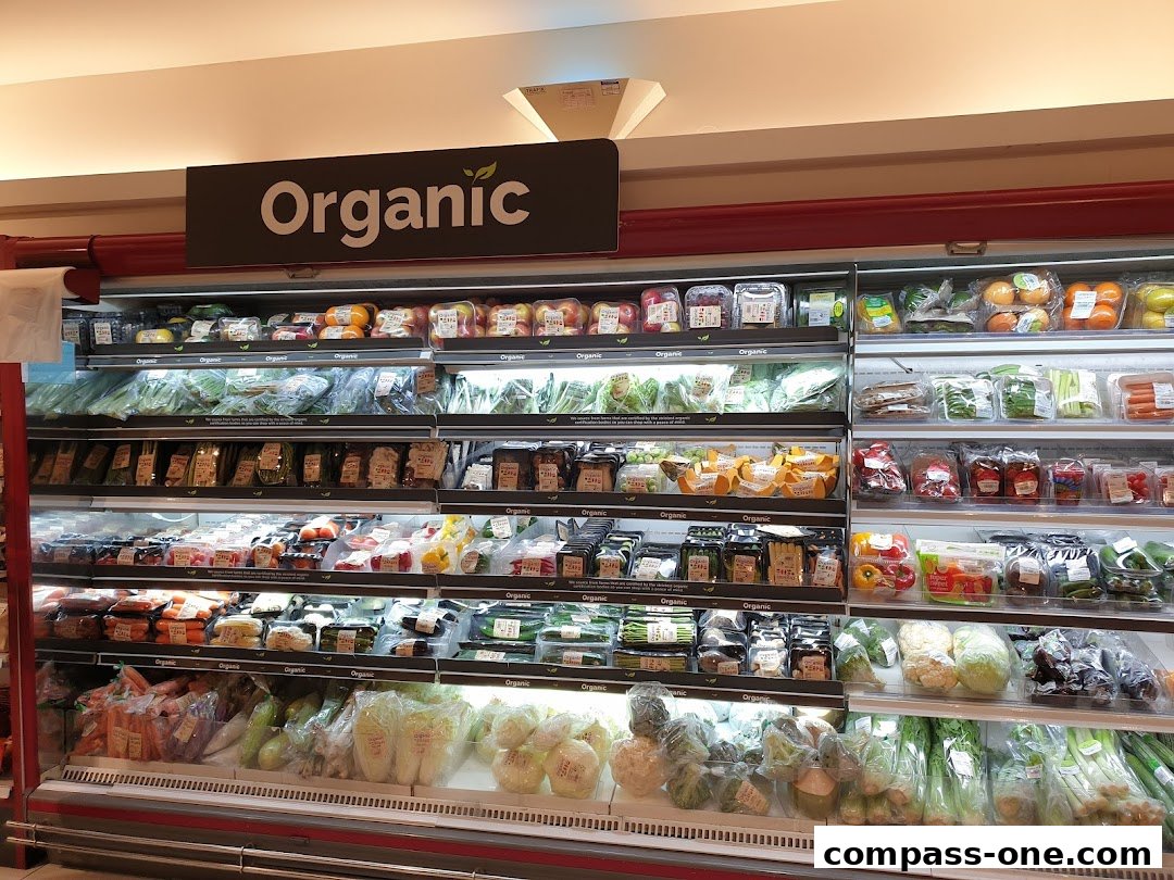 A wide selection of fresh organic fruits and vegetables displayed in refrigerated shelves.