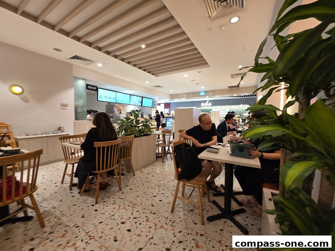 Interior of a cafe with people dining and a pick-up counter.