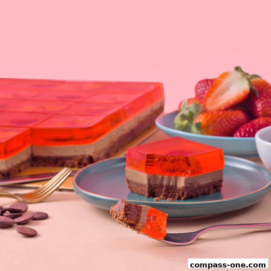 A slice of layered jelly cake with chocolate and strawberries on a pink background.