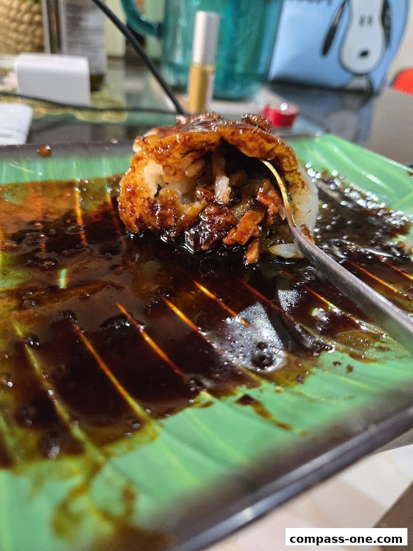 A close-up of a delicious dish with savory sauce on a banana leaf plate.