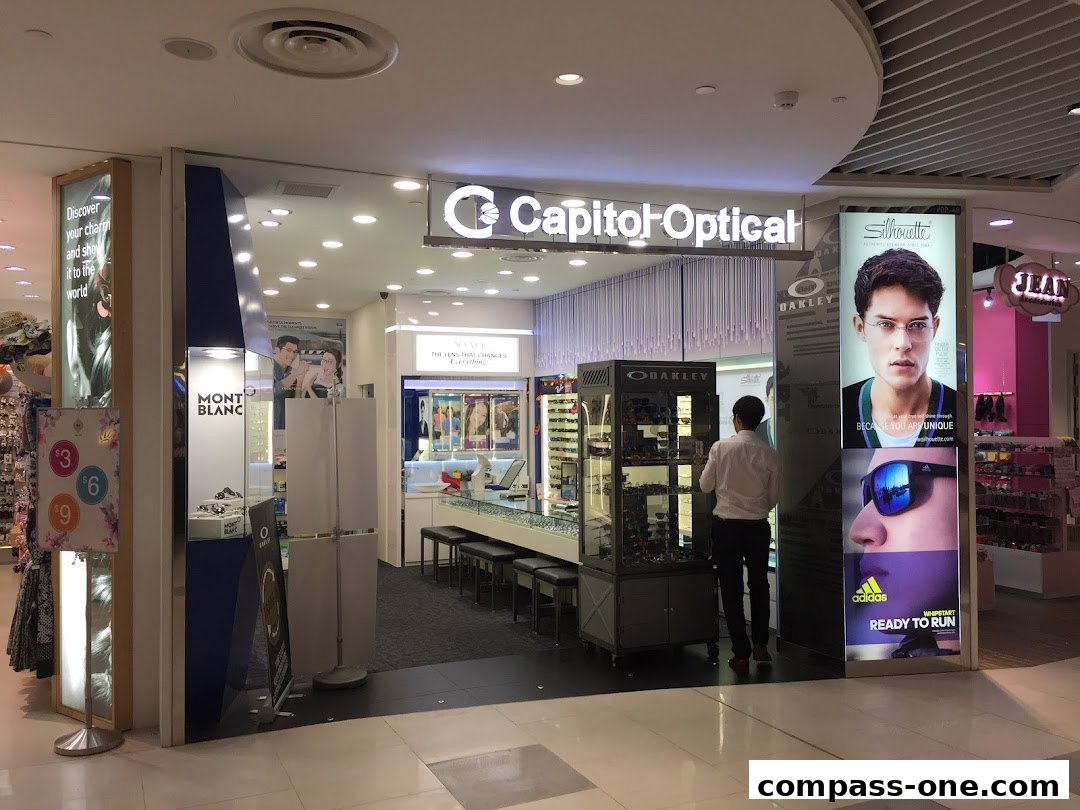 The exterior of Capitol Optical, showcasing eyewear displays and brand advertisements.