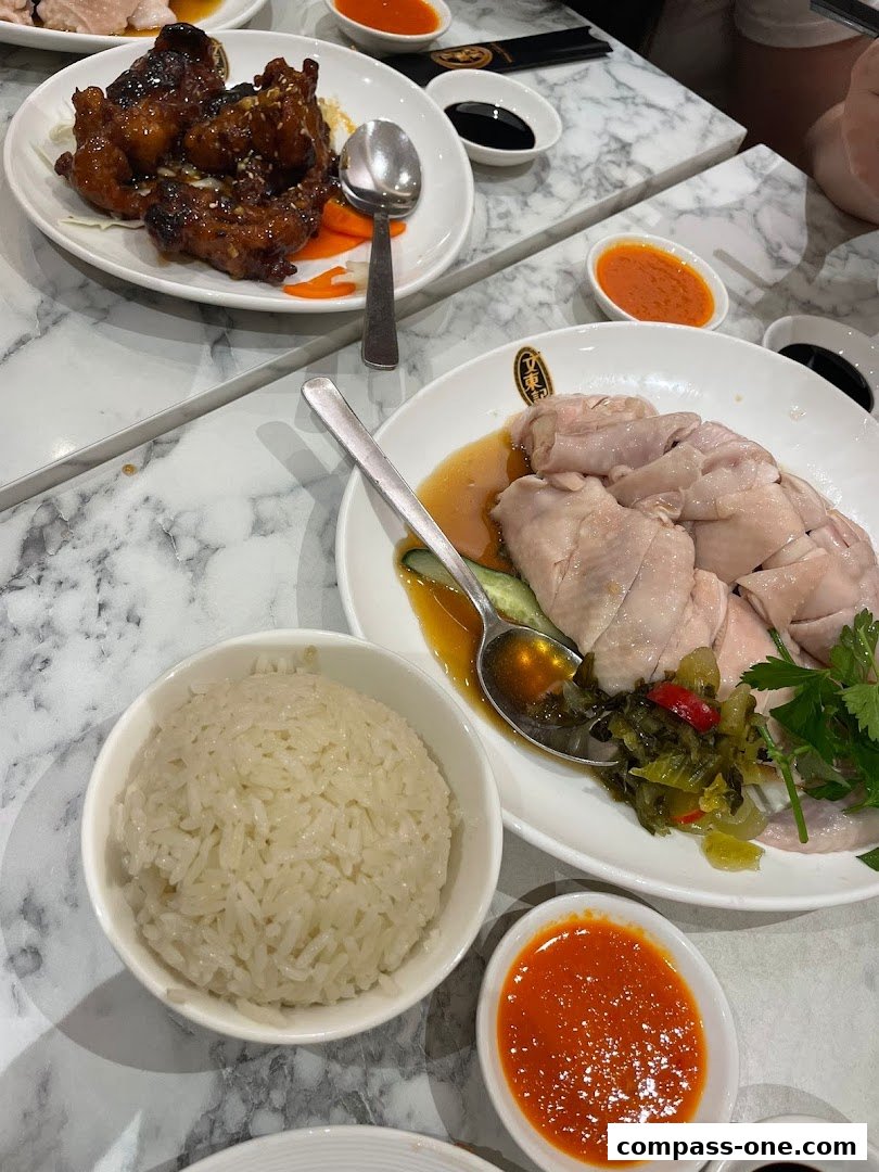 A table laden with delicious Hainanese chicken rice and sweet and sour chicken.