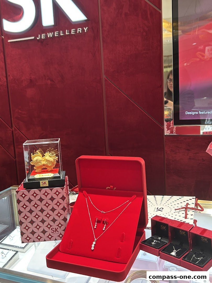 SK Jewellery display featuring a necklace and earrings set, gold figurines, and boxed jewelry.