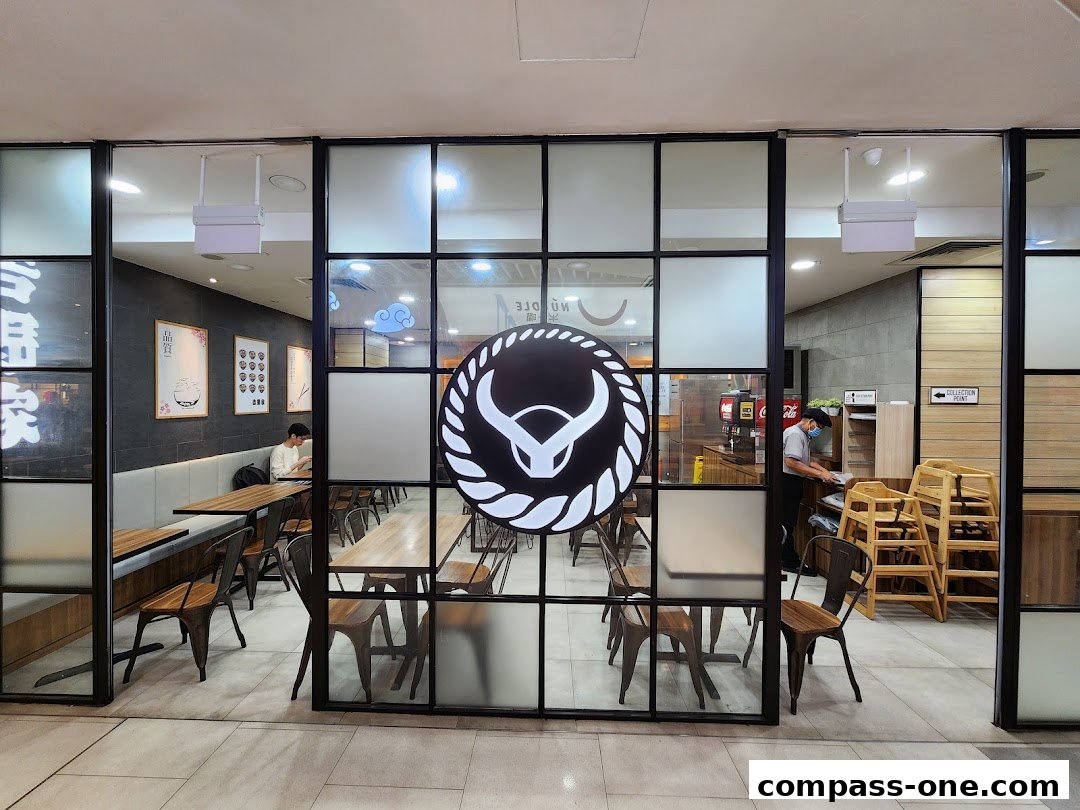 Interior view of Yoshinoya restaurant with seating, a counter, and staff.